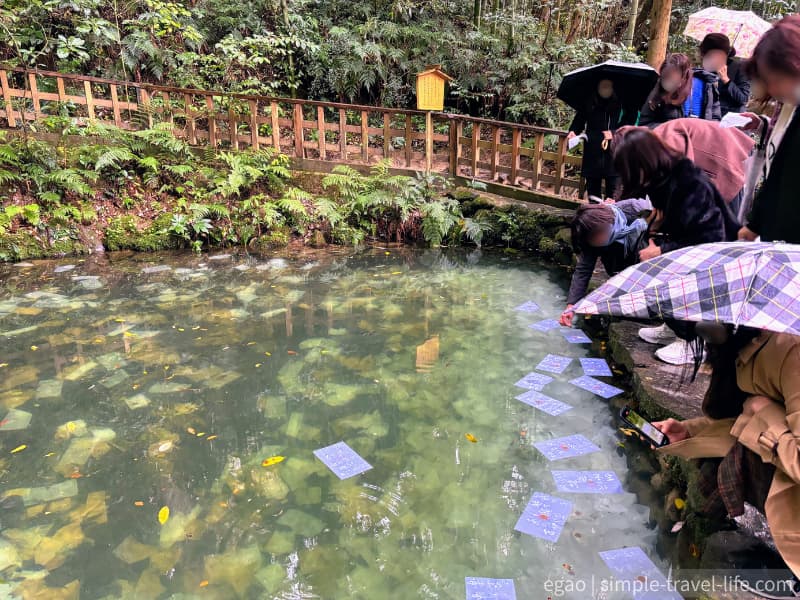 鏡の池で縁占いをする観光客