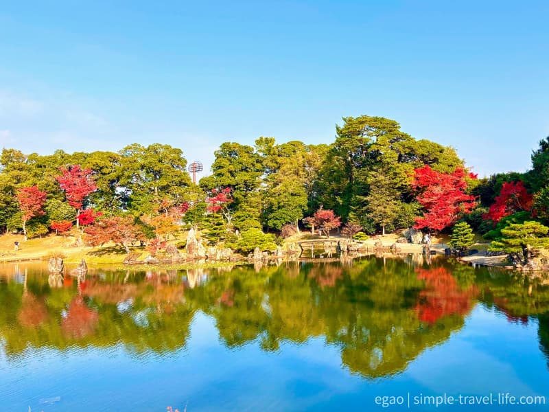 池泉回遊式の庭園の紅葉が映る広大な池の姿