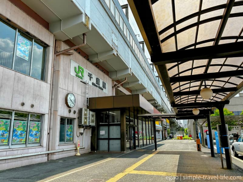 「JR千歳駅」の緑色の看板が掲げられた駅舎と、アーケードの続く歩道