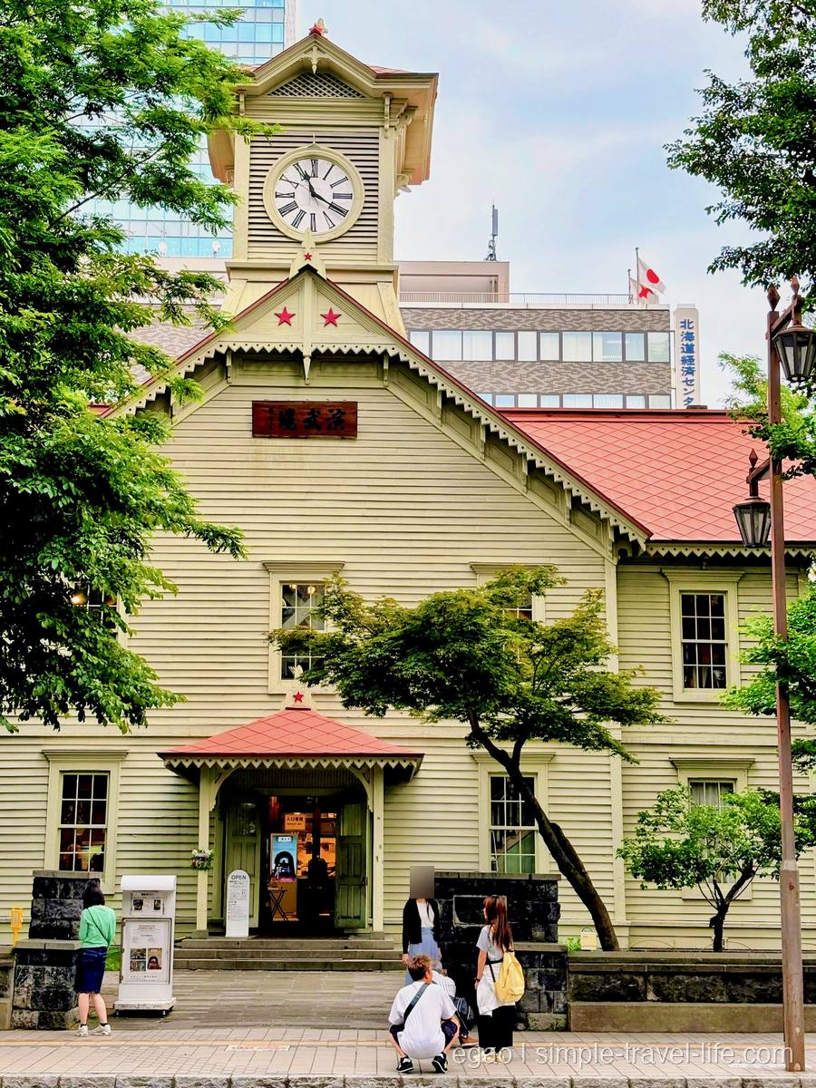 時計塔と赤い屋根をもつ淡い黄色の木造建築、札幌市時計台の正面