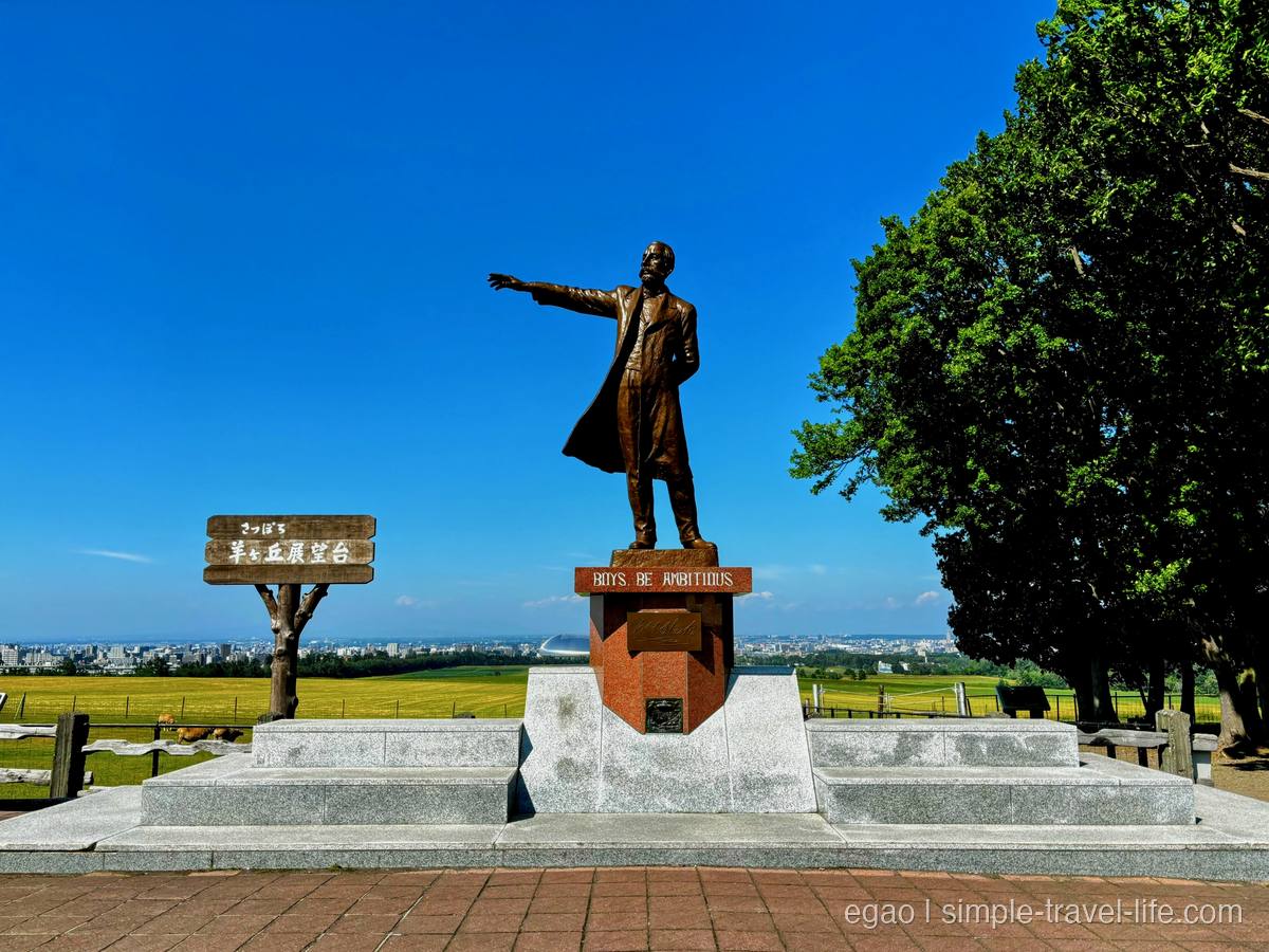 右手を高く挙げたクラーク博士像と、台座に刻まれた「BOYS, BE AMBITIOUS」の文字