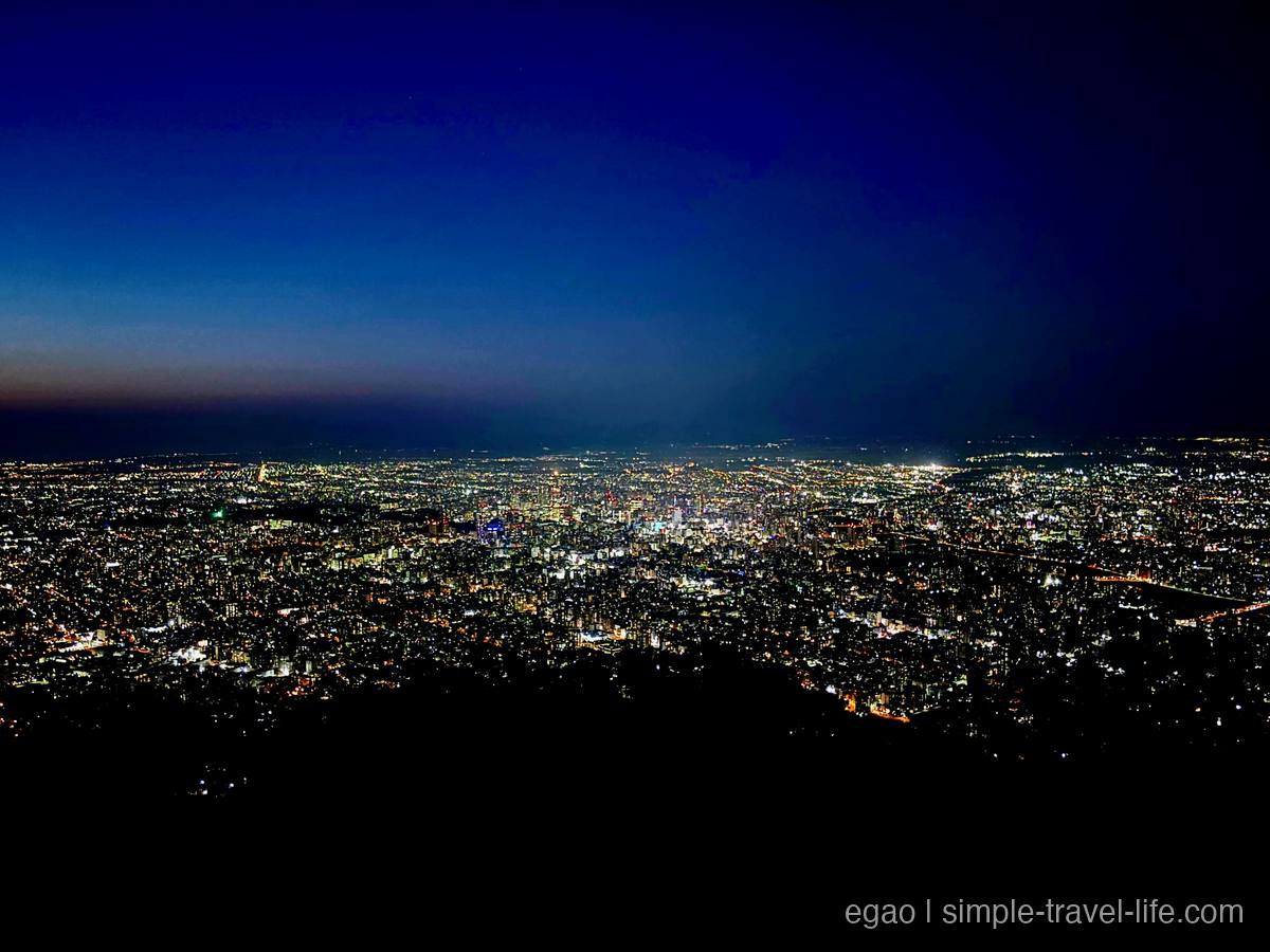 山頂から見下ろす札幌の夜景。遠くまで街の明かりが埋め尽くしている