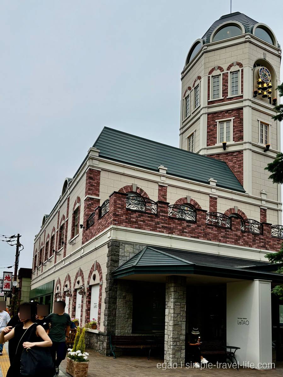 レンガと石を組み合わせた洋館づくりのルタオ本店と、屋上にそびえる時計塔