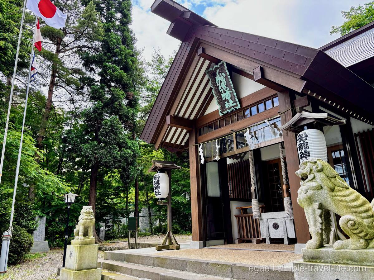 木立に囲まれた船魂神社の木造の拝殿と、「船魂神社」と書かれた白い提灯、両脇の狛犬