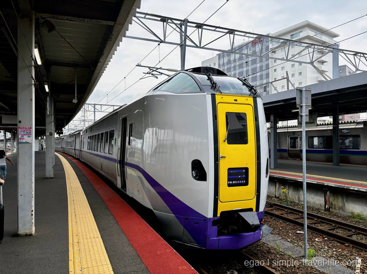 函館駅のホームに停車する特急北斗の先頭車両。白い車体に黄色と紫の帯
