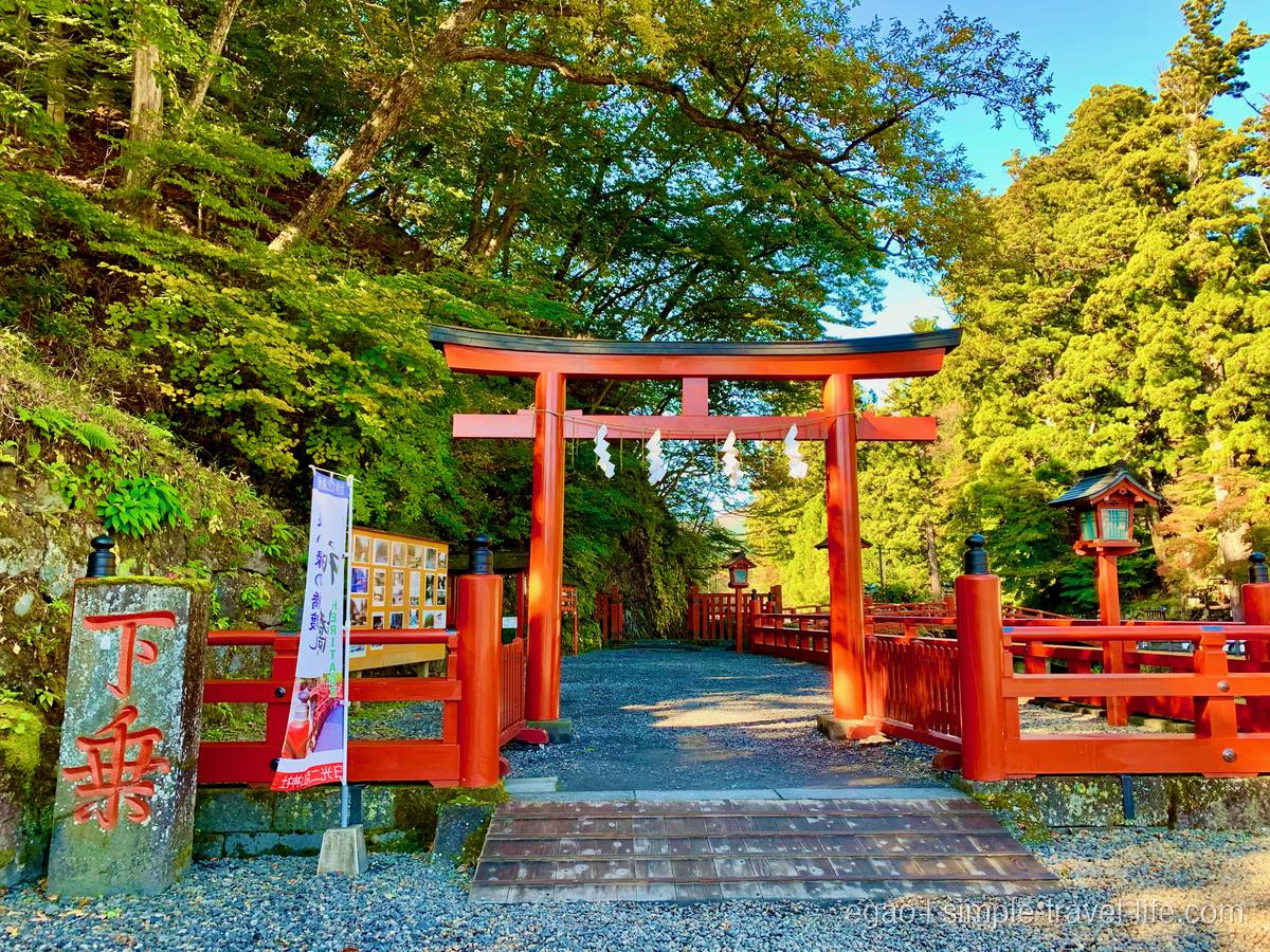 日光の大谷川に架かる朱塗りの神橋を奥に望む景色