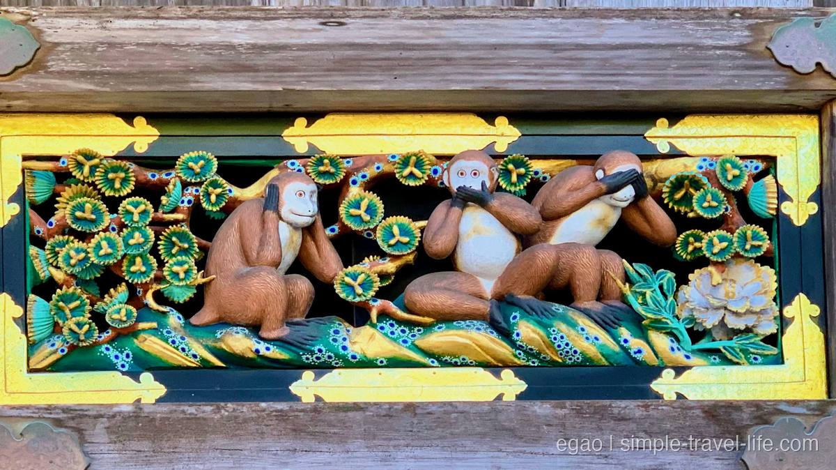 神厩舎の長押に彫られた三猿の彫刻。目・口・耳をふさぐ三匹の猿と、緑と金の彩色