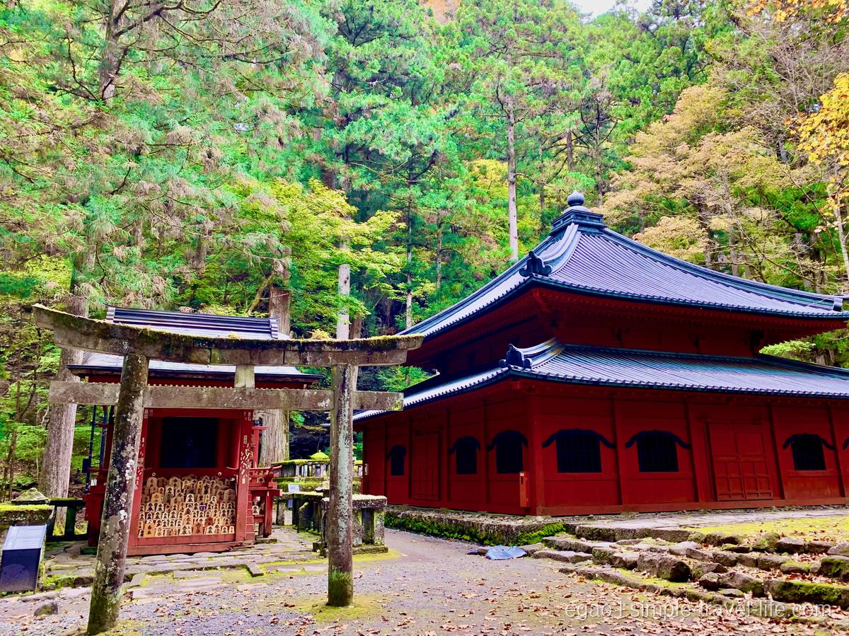 日光山輪王寺の開山堂。重層の宝形屋根の朱塗りのお堂と、左手前の石鳥居・香車の将棋の駒が納められた観音堂